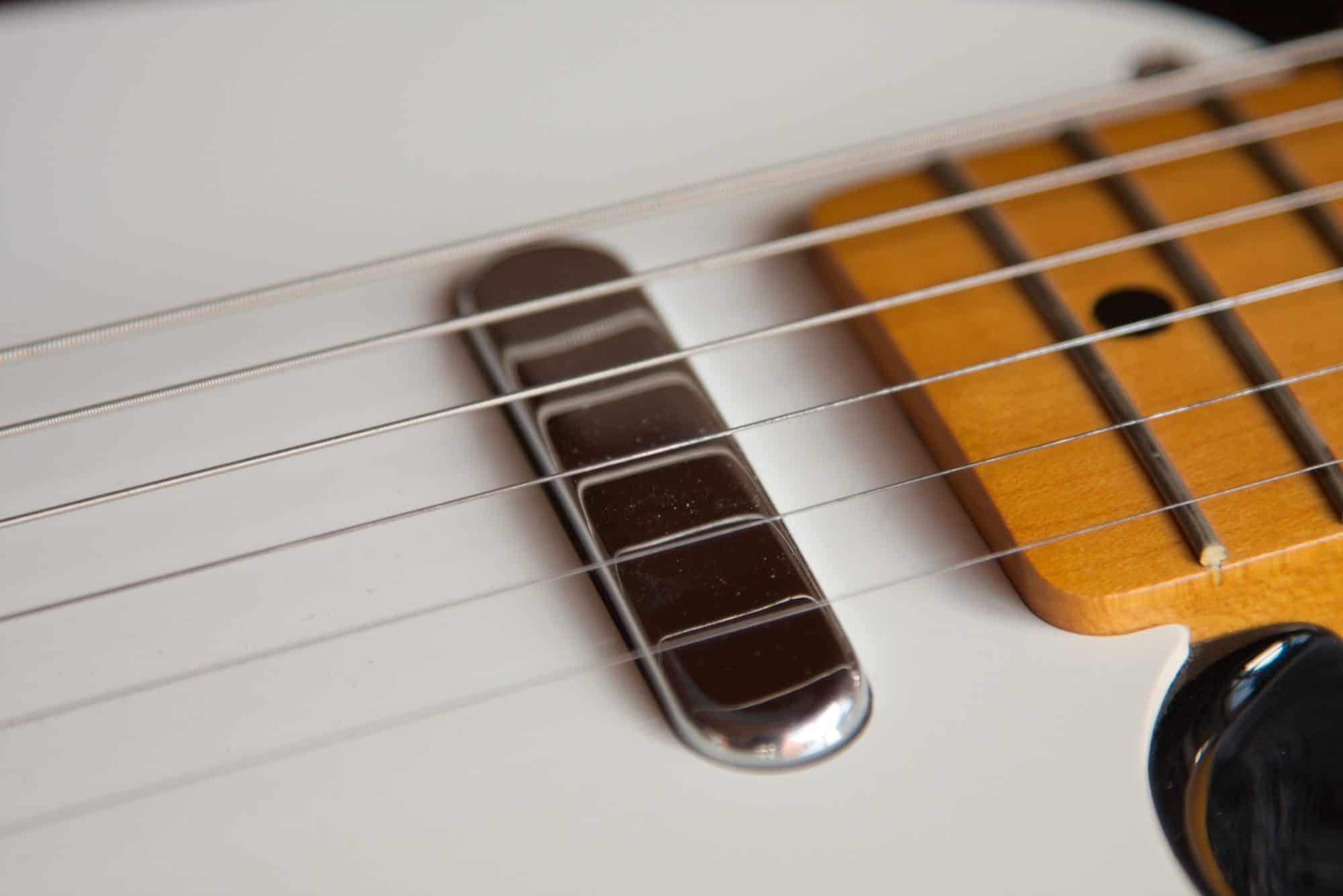 Close up of an electric guitar strings and pickup