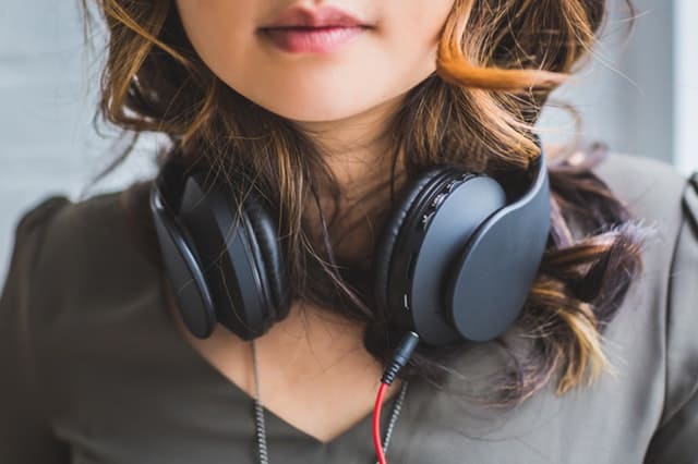 Woman with black headphones resting around her neck